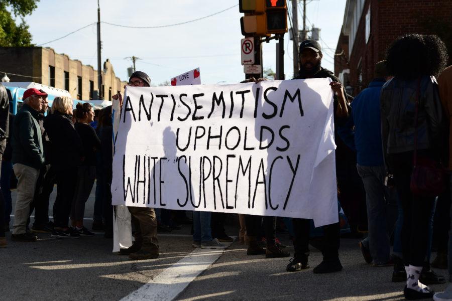 Demonstrators hold a sign in Squirrel Hill on Oct. 30, 2018, after the Tree of Life shooting.