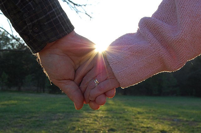 A married couple holds hands.
