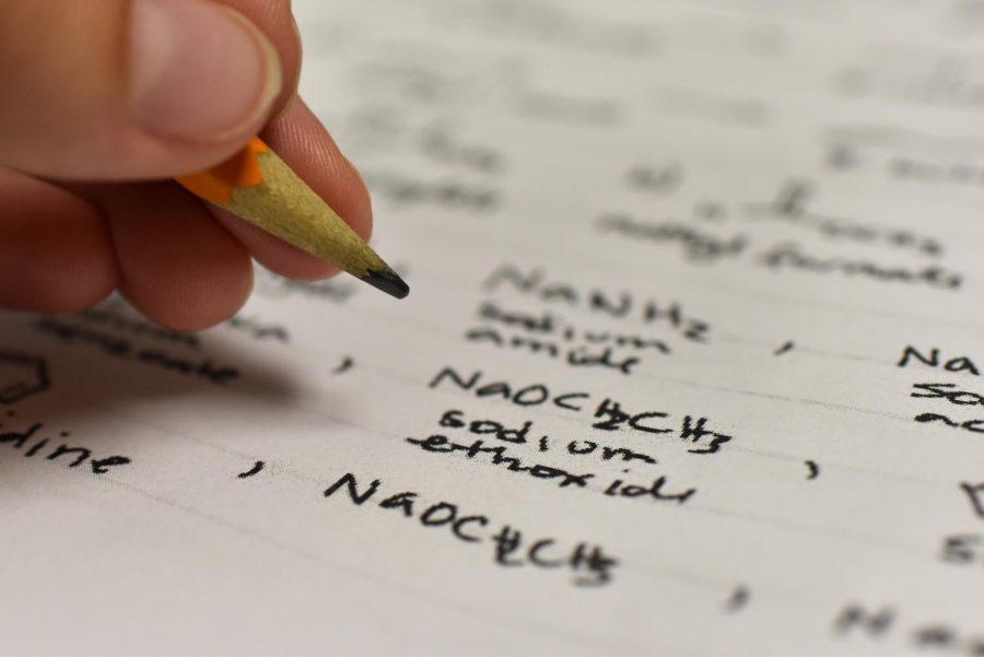 A student writes chemistry problems.