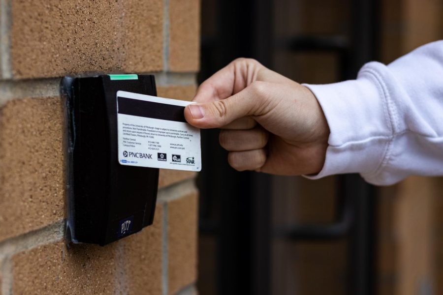 A student swipes an ID card outside of the William Pitt Union.