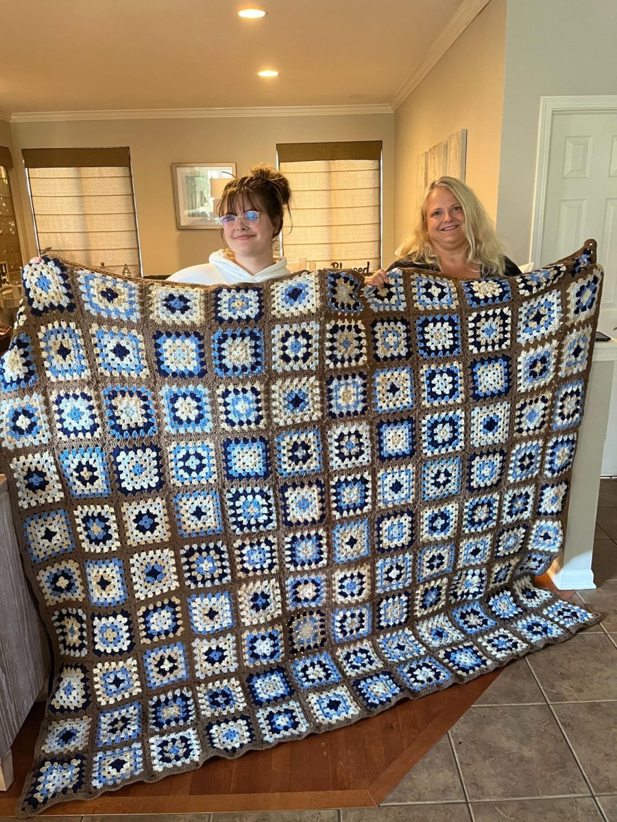 Livia LaMarca and her mother, Leslie, hold up their permutation blanket.