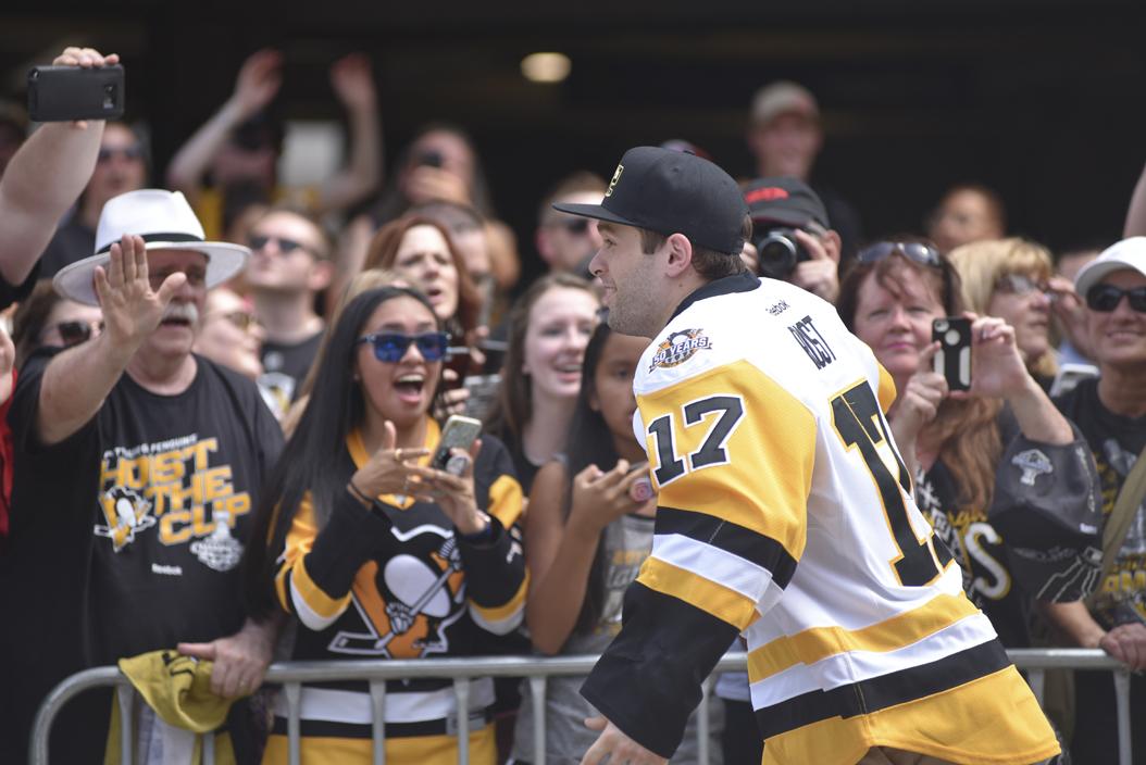 Penguins right winger, Bryan Rust, greets fans along the parade route.