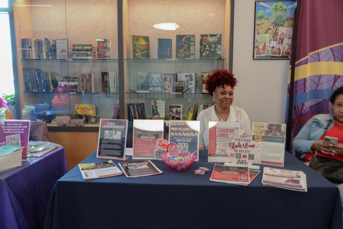A presenter smiles in front of flyers during the Black Maternal Health and Wellness Event at the Pittsburgh Community Engagement Center on Homewood Avenue.
