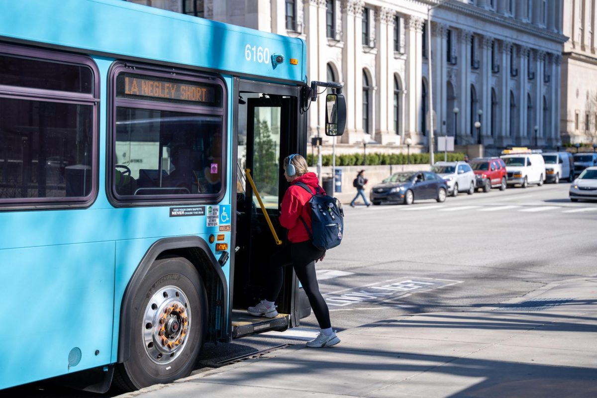 A student boards a PRT bus.