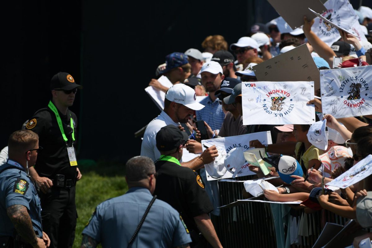 Bryson DeChambeau signs autographs just after his nine hole practice round behind the 18th green on Wednesday June 11 